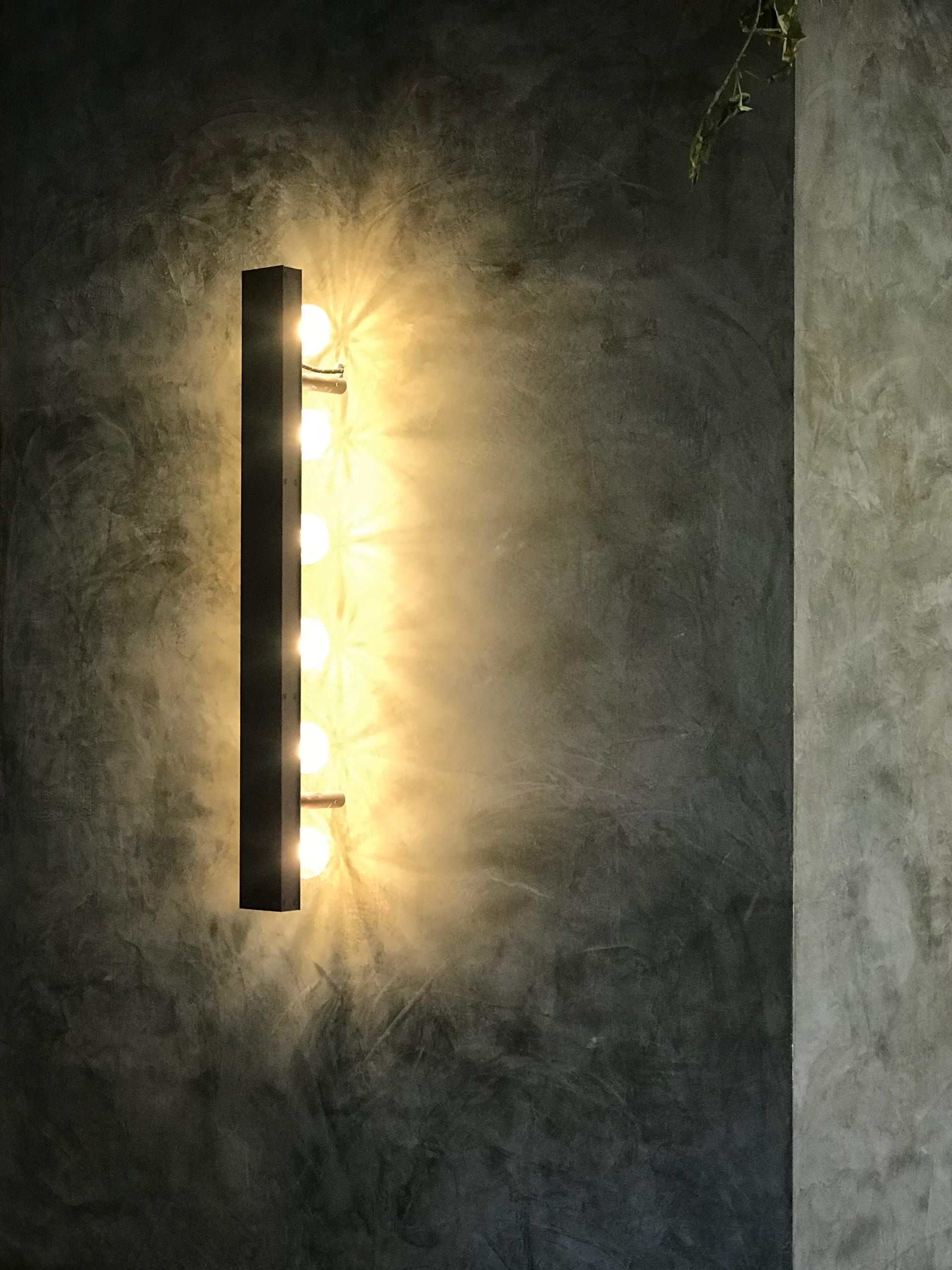 Wall light with six bulbs on a textured grey plaster wall