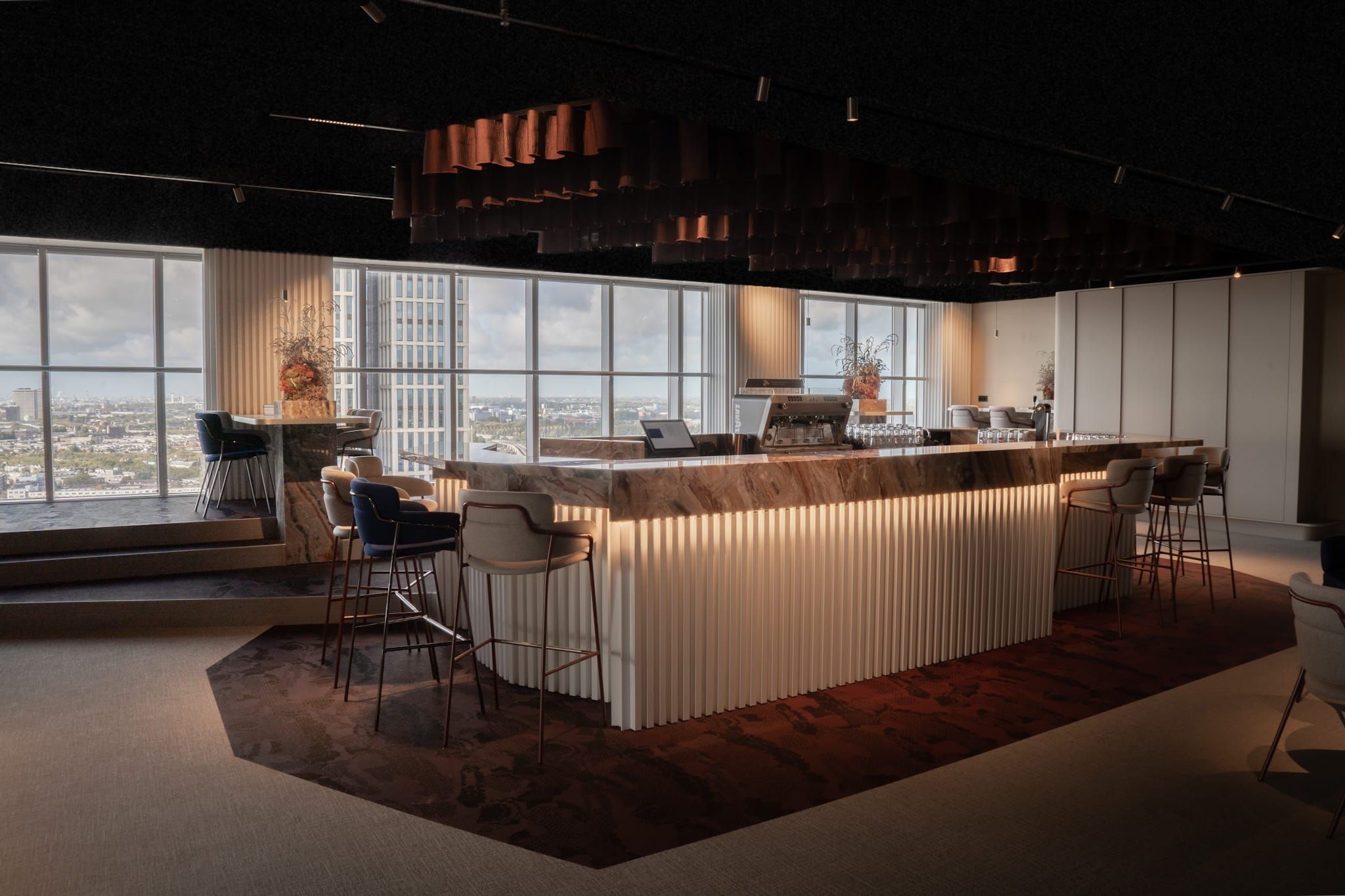 Bar with marble top and fluted front under copper ceiling baffles in the Tuesday office