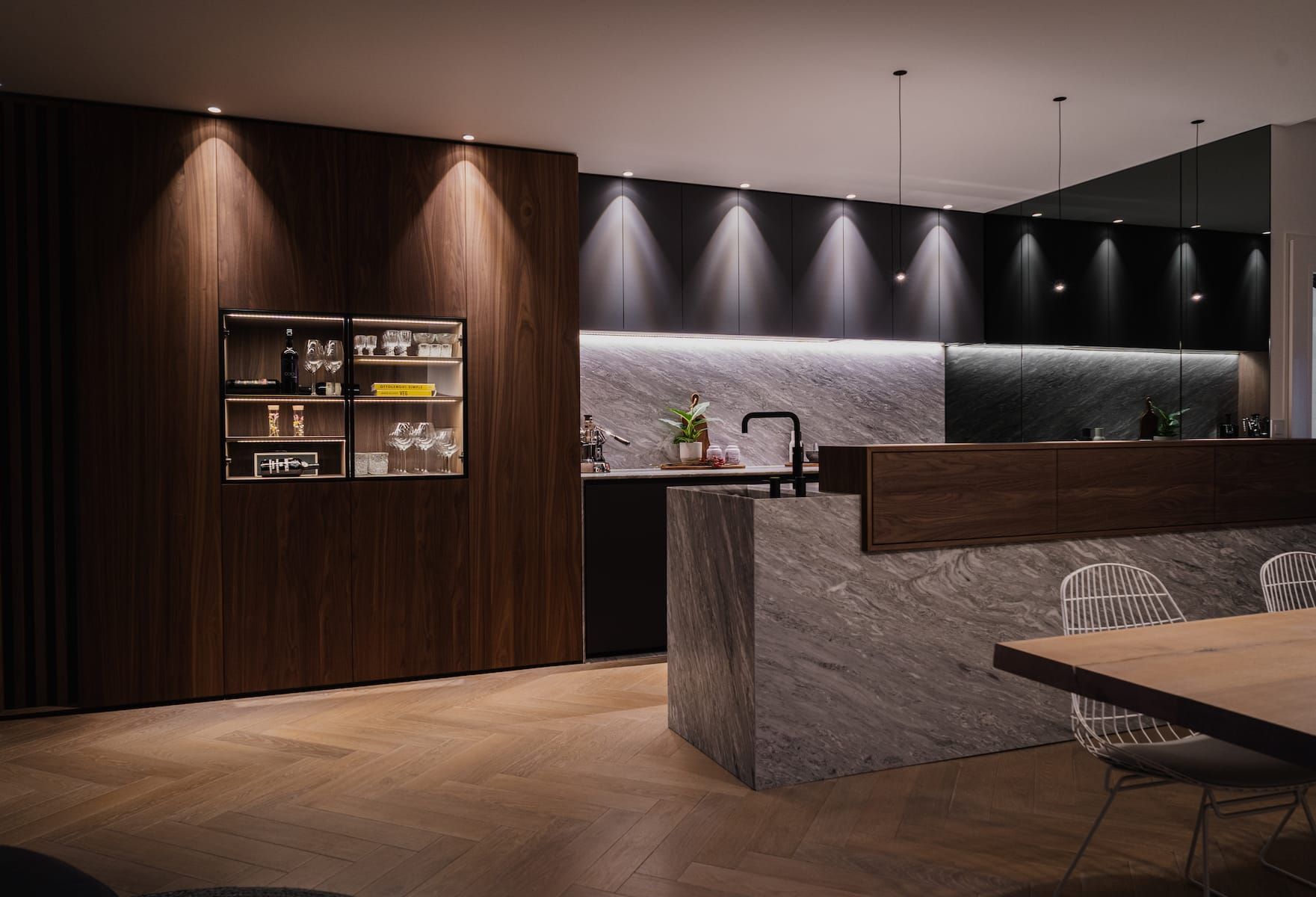 Churchlane kitchen with walnut cabinet wall, stone island and spotlit black cabinets